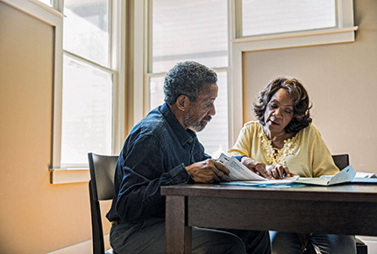 Senior couple paying bills at home