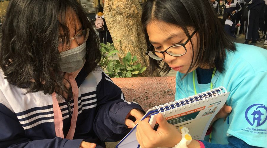 A couple of girls reading a notebook