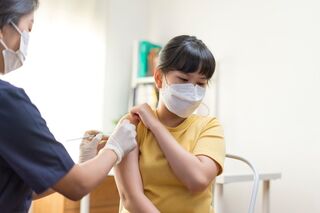 Person being vaccinated by a medical practitioner